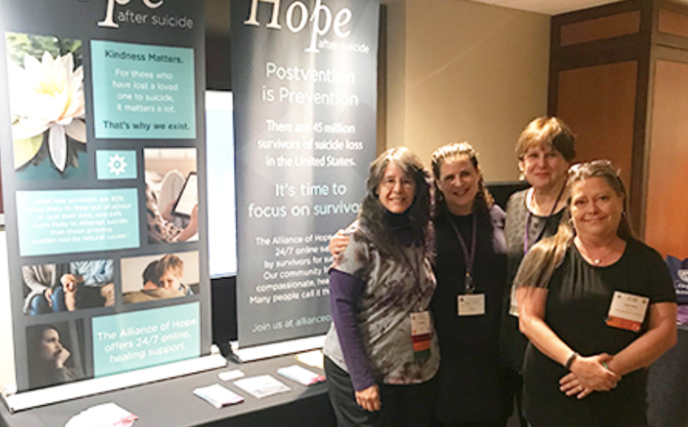 Alliance of Hope members gathered at booth.