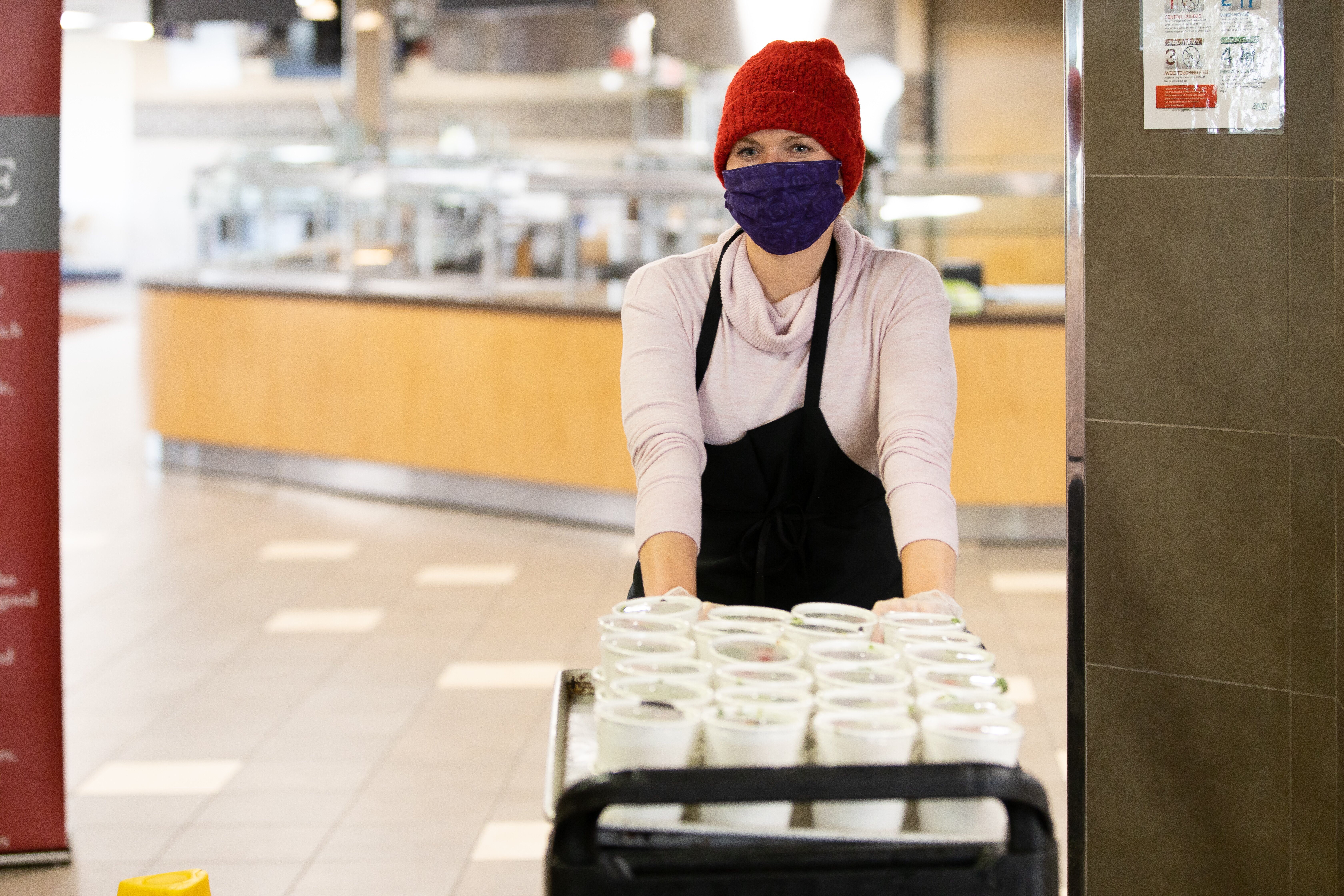 Meals on Wheels Worker pushing cart in facility